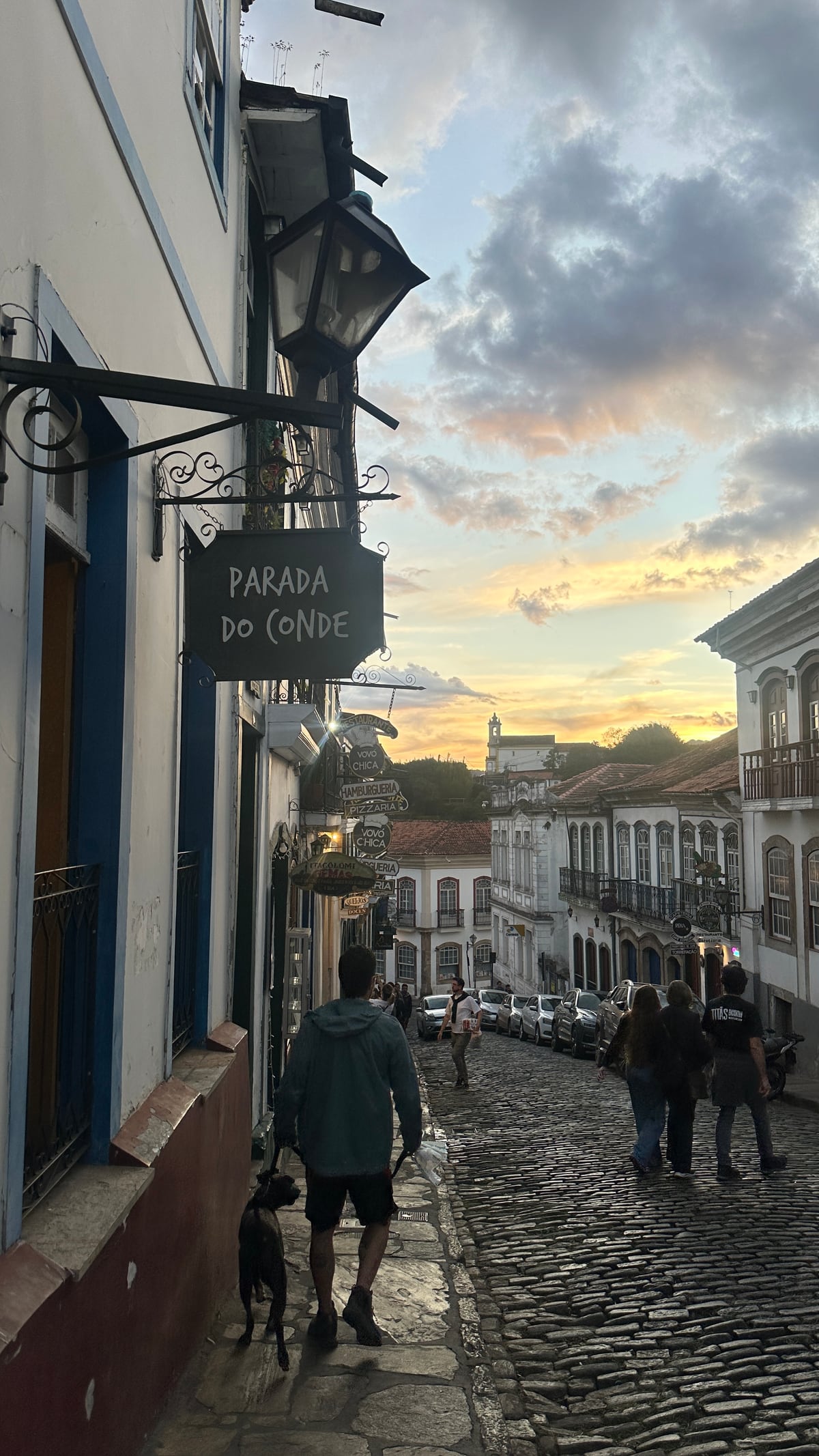 Rua estreita e íngreme de Ouro Preto, com carros encostados dos dois lados