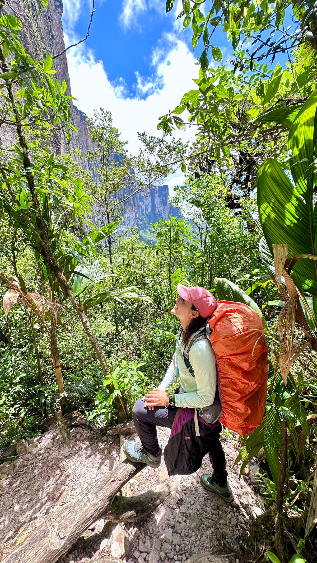 Thaíssa de mochila cargueira, parada na trilha dentro da mata